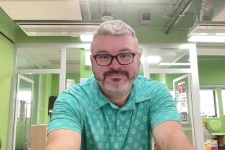 A student taking notes during a video call for online learning at home.